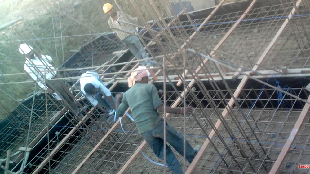 Technicians working at height on structural steelwork with safety netting