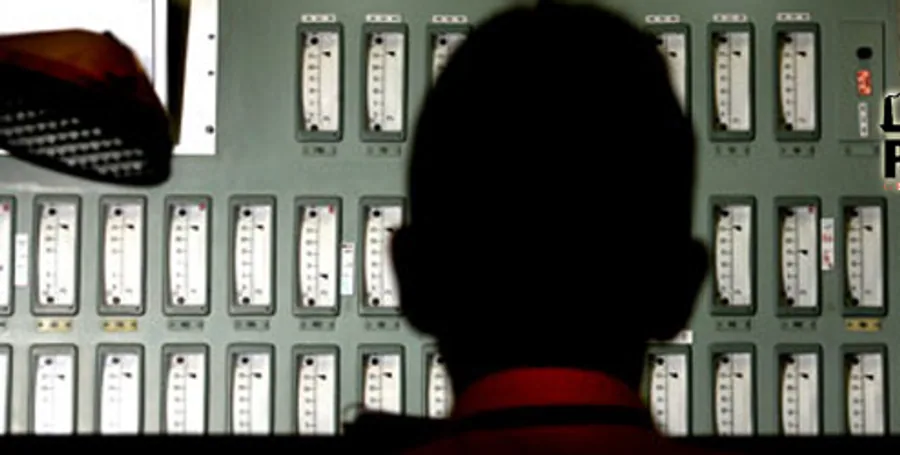 Operator at a control panel within an instrumentation and control room